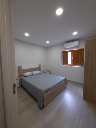 Un dormitorio con una cama grande y una ventana en Casa dos Moroucinhos, en Rio Caldo