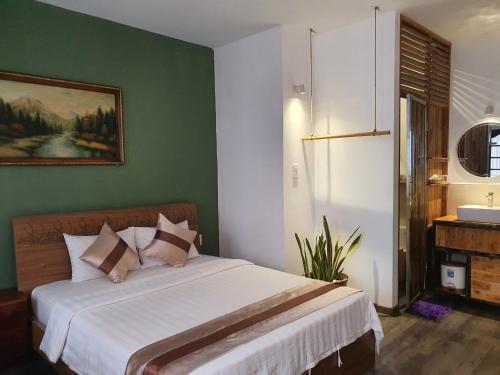 1 dormitorio con cama blanca y pared verde en Tony SaiGon Hotel en Ho Chi Minh