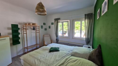 1 dormitorio con 1 cama con pared verde en Ferienwohnung Ollywood, Natur pur im Westerwald, 2 bis 4 Personen, 