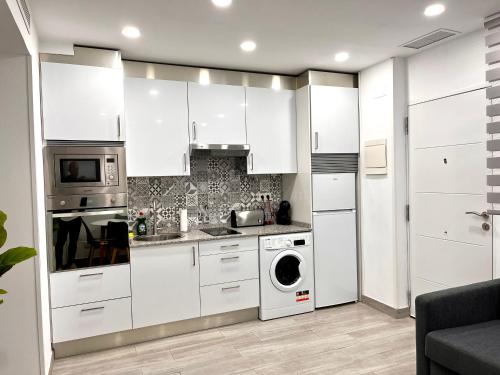 a kitchen with white cabinets and a washer and dryer at Maximilian dreams 2 in Madrid