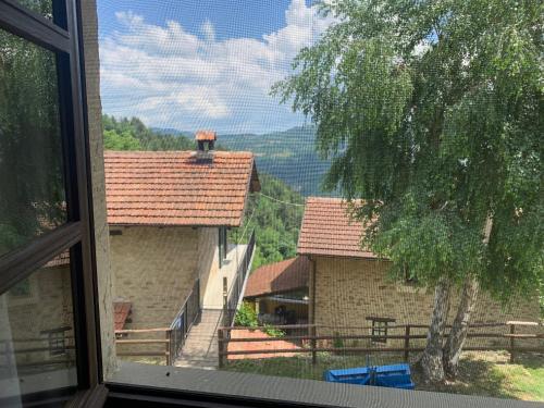 a view from a window of a house with a tree at Agriturismo La Collina degli Scoiattoli in Cravanzana