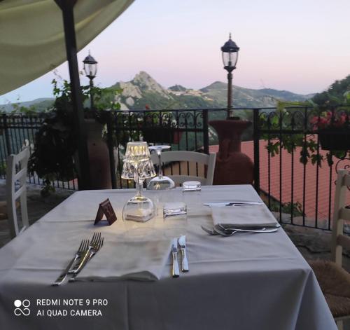 une table avec un chiffon de table blanc et de l'argenterie dans l'établissement Monserrat, à Castelmezzano