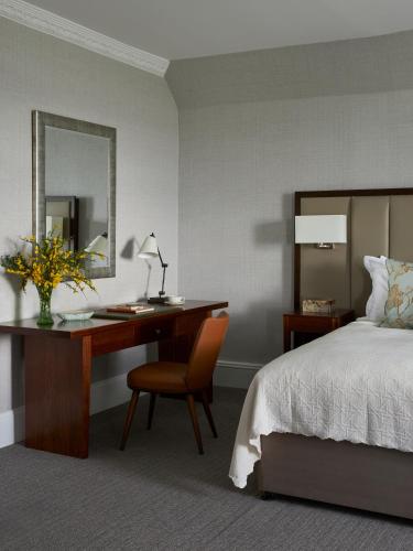 a bedroom with a desk and a bed and a mirror at Marine Troon in Troon