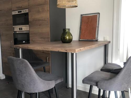 a kitchen with a table with chairs and a vase on it at Mein Eifel Ferienhaus Altes Pfarrhaus in Dahlem