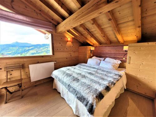 a bedroom with a bed in a wooden house at Superbe chalet avec piscine et hammam à 50m des pistes - FR-1-598-27 in Les Gets