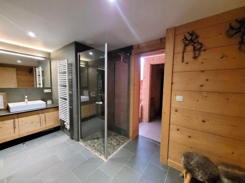 uma casa de banho com uma cabina de duche em vidro e um lavatório. em Chalet Les Gets, 8 pièces, 14 personnes - FR-1-598-27 em Les Gets