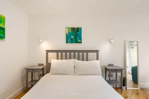 a bedroom with a white bed with two tables at Central, Bright 2 Bed Flat - Pool & Sauna in Edinburgh