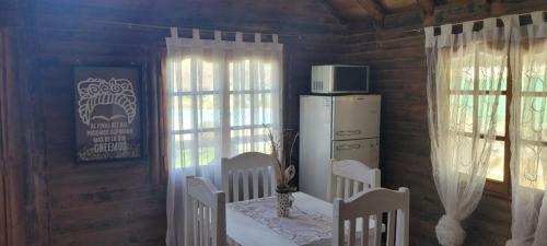 a room with a table and a refrigerator and windows at ENTRE VIÑAS in Ciudad Lujan de Cuyo