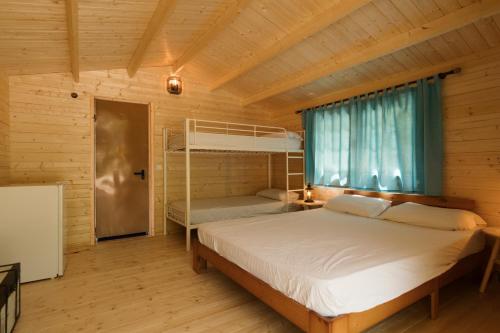 1 dormitorio con 2 literas en una cabaña de madera en Slow Life Camping Venta del Moro en Venta del Moro
