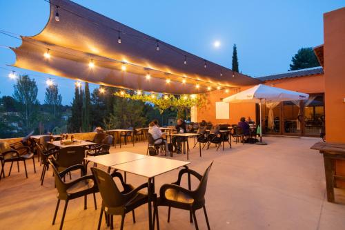 an outdoor patio with tables and chairs and lights at Slow Life Camping Venta del Moro in Venta del Moro