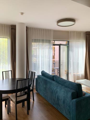 a living room with a blue couch and a table at Park Apartments in Druskininkai