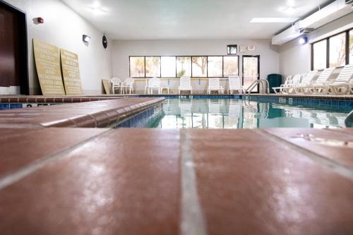 an empty swimming pool with chairs and tables at Comfort Inn & Suites Near Medical Center in San Antonio
