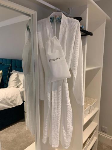 un armario lleno de camisas blancas y una cama en Hideaway Holiday Apartment, en Salisbury