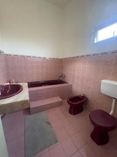 a bathroom with a tub and a toilet and a sink at Baie du Tombeau Apartment in Baie du Tombeau