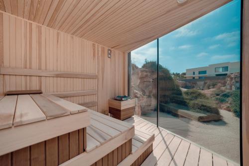 an empty sauna with a large glass window at Periyiali Konnos Villas Beach Resort in Protaras