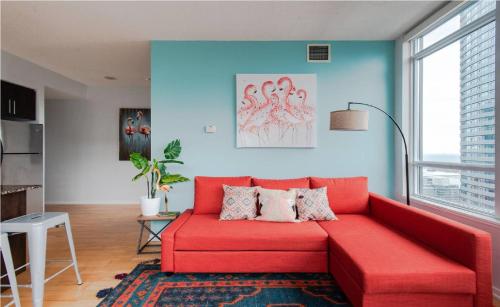 a red couch in a living room with blue walls at Toronto Downtown Core Two Bedroom Condo with CN Tower View, Free Parking in Toronto