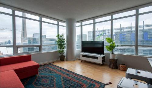 a living room with a red couch and a flat screen tv at Toronto Downtown Core Two Bedroom Condo with CN Tower View, Free Parking in Toronto