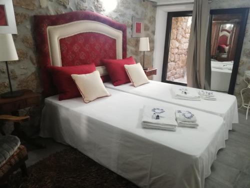 a bedroom with a large white bed with red pillows at 3 Marias - Nº20 - T1 in Lousa