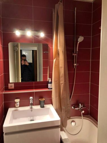un homme prenant une photo d'une salle de bains avec lavabo dans l'établissement Metabief- Front de piste, à Métabief