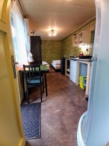 a small kitchen with a table and a refrigerator at Nad rybníkem Hnačov - rodinný rekreační areál in Hnačov