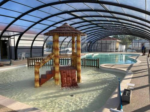 a swimming pool with a water slide in a building at Camping de la Plage in Marck