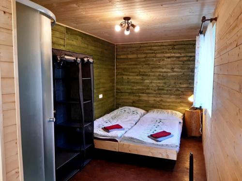 a small bedroom with a bed and a wooden wall at Nad rybníkem Hnačov - rodinný rekreační areál in Hnačov