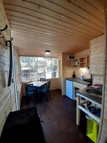 a small kitchen with a table and a dining room at Nad rybníkem Hnačov - rodinný rekreační areál in Hnačov