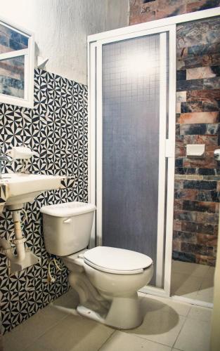a bathroom with a toilet and a sink at Hotel Cupules in Mérida