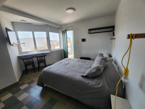 a bedroom with a bed and a table with chairs at CASA MARGARITA 5Piso Mono Verde Oscuro in San Salvador de Jujuy