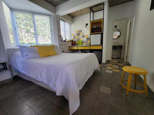 um quarto com uma cama e um banco em CASA MARGARITA 4Piso MonoAmarillo em San Salvador de Jujuy