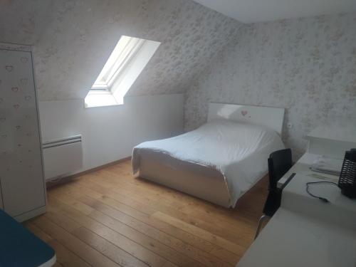 a small bedroom with a bed and a skylight at Chambre privée à Bobigny -salle de bain et toilettes sont commune, -pas de cuisine in Bobigny