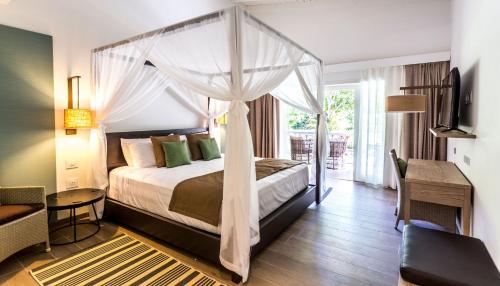 a bedroom with a bed with a canopy at Wyndham Tortola BVI Lambert Beach Resort in East End