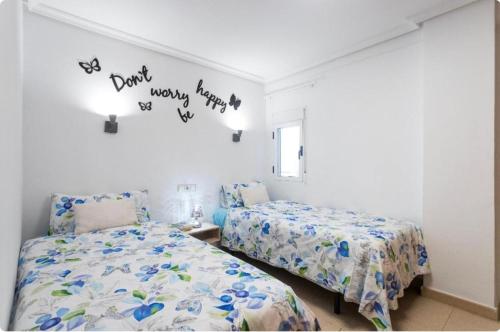 una camera con due letti e parole sul muro di Payma Apartments Benidorm a Benidorm
