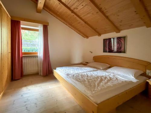 Schlafzimmer mit einem Bett und einem Fenster in der Unterkunft Dolomiten View - South Tyrol in Villanders