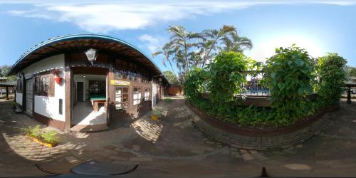 a small building with a roof with trees and plants at Quari Quara BY MN Hotéis in Rio das Ostras