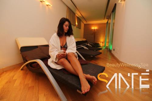 a woman sitting on top of a bed at Park Hotel Sant'Elia in Fasano