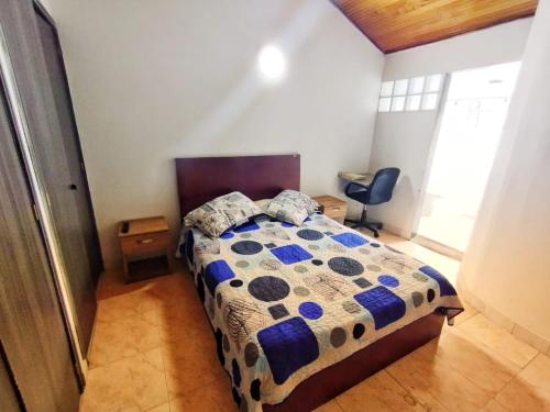 een slaapkamer met een bed en een stoel erin bij Aloha Hostel in Bogota