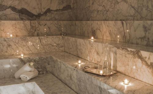 uma casa de banho com uma banheira em mármore com velas em Yoo Punta Del Este em Punta del Este