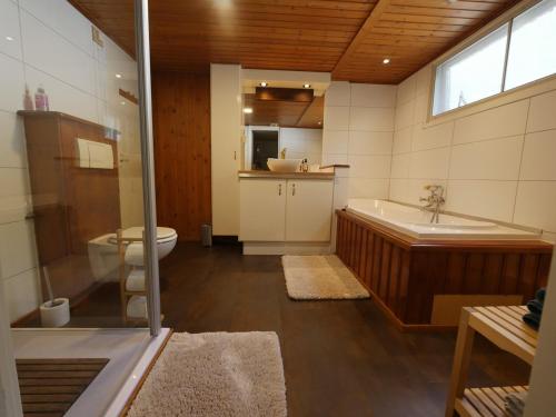 ein Badezimmer mit einer Badewanne, einem WC und einem Waschbecken in der Unterkunft Perfect get away - Cosy Cabin in the Woods in Diessen