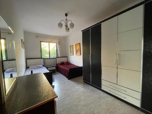 een woonkamer met een bed en een grote kast bij Lovely spacious house with big garden in Elbasan
