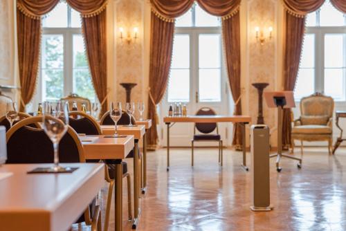 a dining room with tables and chairs and windows at Robenstein Hotel & SPA - Villa in Zwiesel