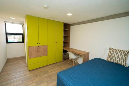a bedroom with a bed and a desk and yellow cabinets at +MS +Loft Coworking +Vigilancia 24hrs +Internet 504 in Laborcillas