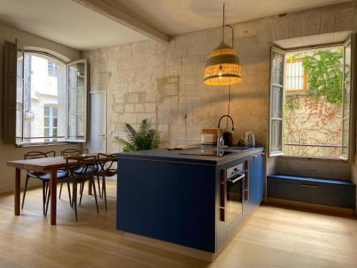 une cuisine avec un îlot bleu et une table dans l'établissement Appartement climatisé plein centre historique, à Avignon
