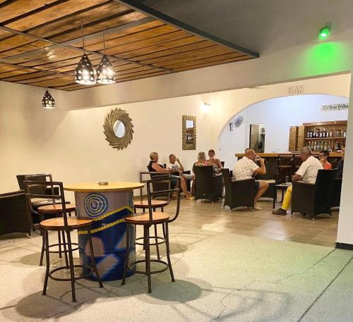 a group of people sitting at a bar in a restaurant at Villa des Pêcheurs Beach Hôtel in Cap Skirring