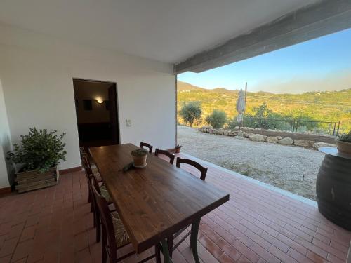 a wooden table and chairs on a patio with a view at La Casa di Demetra. Un Paradiso tra gli Olivi. in Montecchio