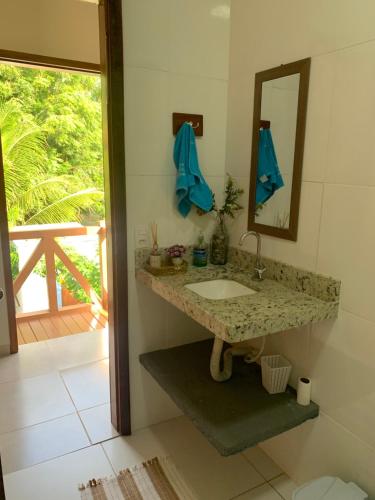 ein Badezimmer mit Waschbecken und Spiegel in der Unterkunft Chalé Estrela da Barra in Barra Grande