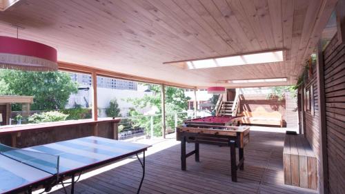 a room with a ping pong table on a deck at Happy House Hostel in Santiago