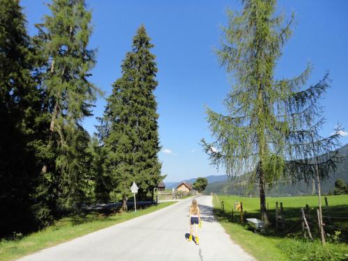 a woman walking down a road with a skateboard at Kirchenbichlerhof in Pruggern
