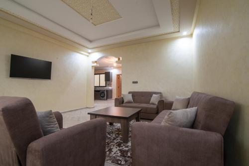 a living room with couches and a table and a tv at Adam's Apartments,Self CheckIn 6 Mins to Beach Downtown Fiber Optic WiFi Free Parking Same Rules as Hotels in Agadir