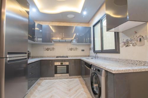 a kitchen with a washer and dryer in it at Adam's Apartments,Self CheckIn 6 Mins to Beach Downtown Fiber Optic WiFi Free Parking Same Rules as Hotels in Agadir